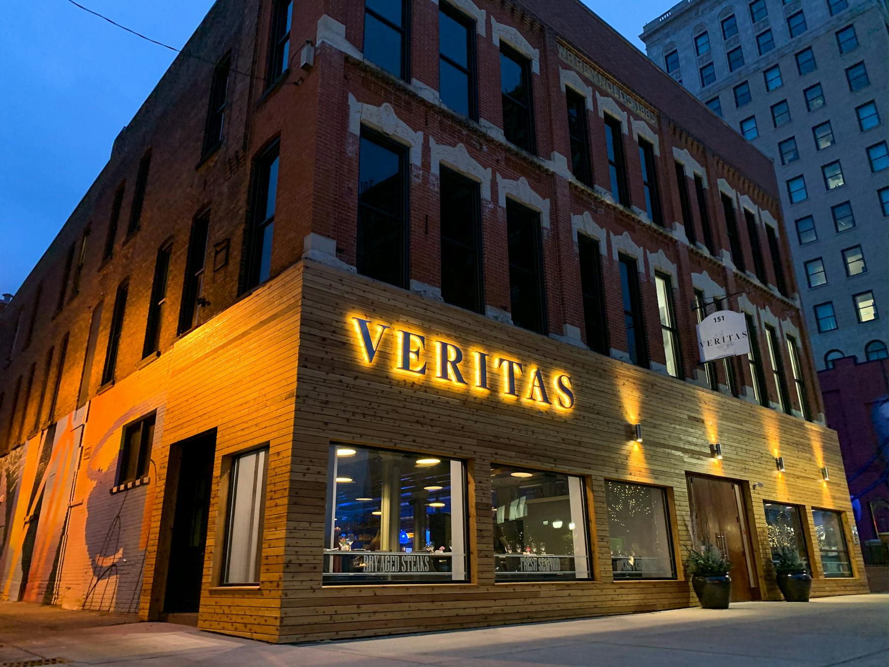 a large brick building with a clock on the side of the street